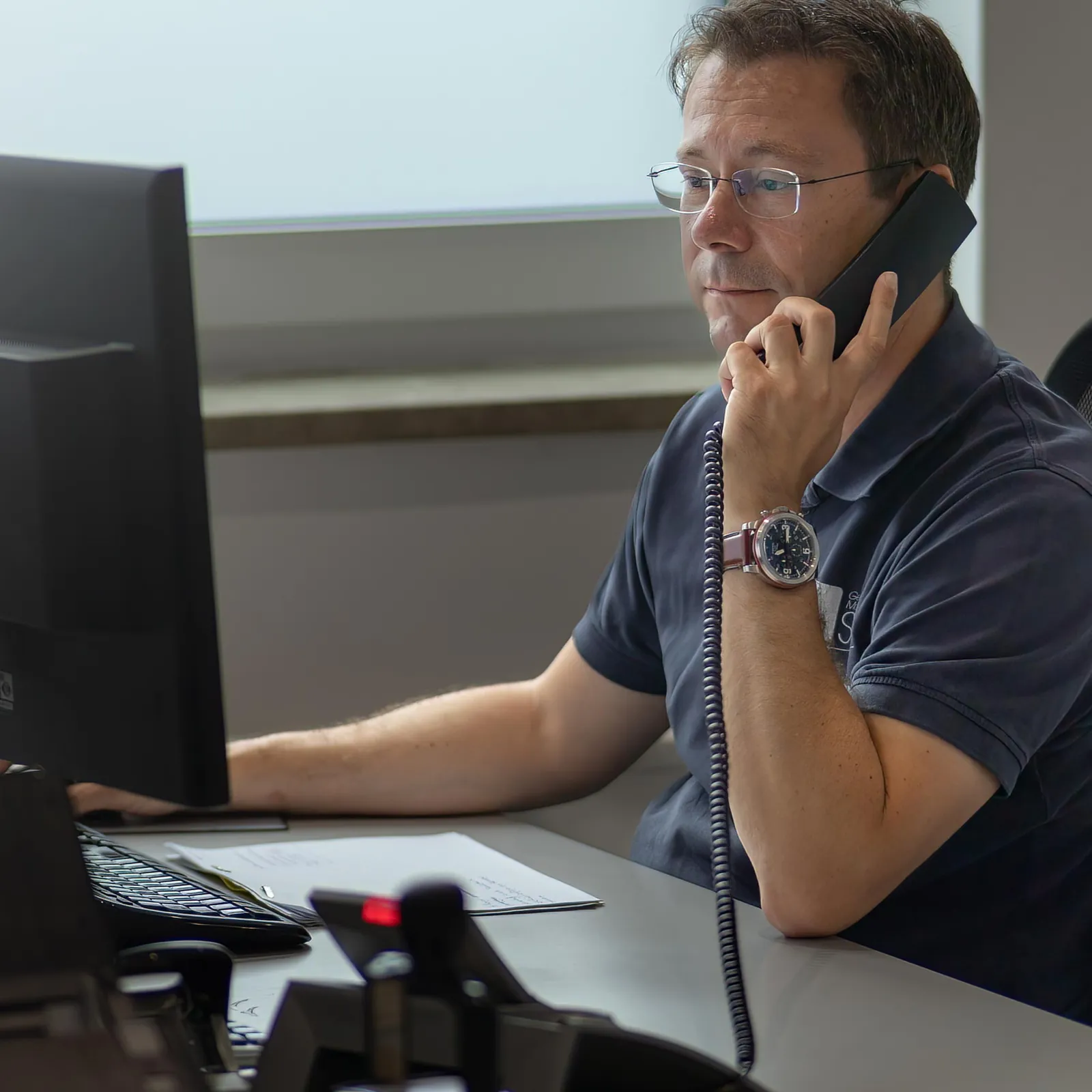 GM-Süd-Mitarbeiter am Telefon im Büro